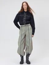 Pantalón sastrero de tiro medio y pierna ancha, con diseño a rayas verticales finas y detalle de vivos negros en la pretina y a lo largo del frente.