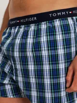 Pack de tres bóxers de algodón con cintura elástica con logo Tommy Hilfiger. Incluye un bóxer a cuadros azules y blancos, un bóxer negro con lunares blancos y un bóxer a cuadros verdes y azules.