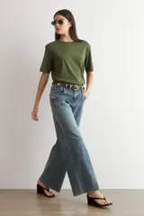Pantalón de jean estilo wide leg con tiro medio, corte holgado y ruedo deshilachado.