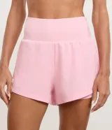 Bermuda deportiva Get Over de microfibra color verde claro, con diseño de doble capa que incluye un short interno ajustado y una capa externa suelta con dobladillo redondeado. Cuenta con cintura alta.
