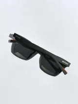 Lentes de sol con armazón bicolor, frente negro y patillas en tono beige con detalle de marca grabado. Cuentan con cristales polarizados con protección UV 400.
