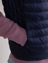 Chaleco acolchado azul marino confeccionado en nylon reciclado repelente al agua, con diseño slim fit, cremallera central y bolsillos laterales.