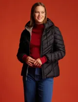 Campera de abrigo verde esmeralda, marca Michael Kors. Diseño acolchado con cierre metálico central, capucha no desmontable con cordón de ajuste y bolsillos verticales delanteros. Incluye bolsa autoportante.