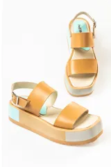 Sandalias negras de cuero con plataforma blanca y hebilla metálica.