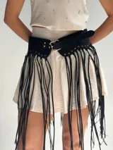 Cinto ancho de gamuza color negro con hebilla metálica dorada y flecos largos.