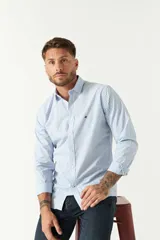 Camisa de manga larga para hombre, color azul claro con microestampado de cuadros. Presenta un corte slim y cuello abotonado.
