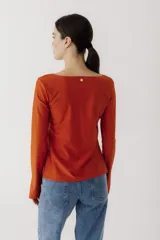 Remera de manga larga con cuello bote, confeccionada en tejido de algodón. Presenta un corte recto y aberturas laterales en los puños.