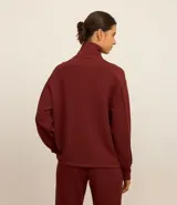 Campera deportiva negra confeccionada en microfibra pesada, con cuello alto doblado, cremallera delantera con cordón en el tirador y puños ajustados.