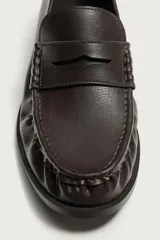 Mocasín de vestir marrón oscuro para hombre, con diseño de antifaz en el empeine, detalle fruncido en la parte delantera y suela con ligero tacón.