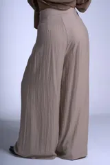 Pantalón negro de corte sastrero con tablas frontales y cintura con lazo. Diseño de pierna ancha y tiro alto.