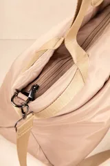 Bolso tipo shopper color beige, con asas fijas superiores y correa desmontable y regulable. Cuenta con dos bolsillos externos y tres bolsillos internos.