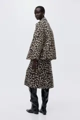 Pollera midi de tiro alto con estampado de leopardo, diseño recto y abertura posterior.