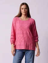 Blusa blanca con bordado calado tipo broderie, de mangas largas abullonadas.
