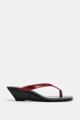 Sandalias destalonadas de cuero, tipo ojota con taco cuña negro y tira delantera en color bordó.