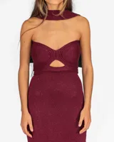 Vestido largo bordó con acabado brillante, diseño strapless con corte estructurado en el busto y abertura frontal tipo cutout, acompañado de un cuello halter integrado de tela a juego.