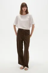 Pantalon de corte recto y holgado, color marrón, con bolsillos frontales tipo cargo y cintura ajustable con cordón trenzado.