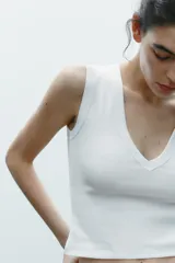 Camiseta negra de corte ajustado (slim fit) con escote en pico profundo y manga sisa.