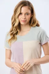 Remera de manga corta con diseño de bloques de color en tonos verde menta, beige y lila, corte clásico y cuello redondo.