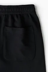 Short de felpa liviana de algodón color negro, con cintura elástica, bolsillos laterales y corte estándar.