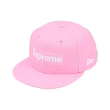 Gorra tipo cap de seis paneles en color rosa, con el logo de Supreme bordado en el frente y el logo de New Era en el lateral.