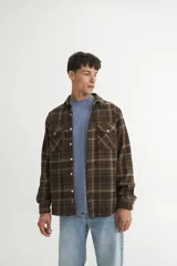 Sobrecamisa a cuadros azul marino y ocre, de franela gruesa, con cuello solapa clásico, calce holgado, bolsillos en el pecho con tapa y botones personalizados.