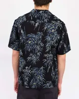 Camisa de manga corta negra con estampado de bambú en tonos azules y amarillos, cuello cuban y cierre frontal de botones.