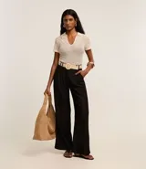 Pantalón wide leg de cintura alta color negro, confeccionado en viscolino, con trabillas en la cintura, cierre tradicional y pliegues. Incluye cinturón de rafia artificial.