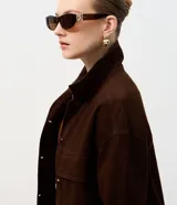 Campera de sarga acanalada color marrón, con cuello camisero estructurado, cierre frontal con botones, mangas largas con puños y bolsillos delanteros con solapa.