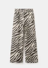 Jeans de corte wide leg con estampado animal print tipo cebra en tonos beige y negro, tiro medio y diseño de pernera ancha.