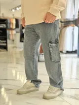 Pantalón de jean cargo color azul, con bolsillos laterales con solapa en los muslos, corte recto y holgado.