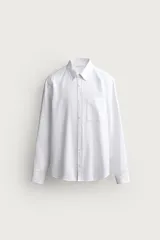 Camisa blanca de corte regular fit, confeccionada en mezcla de lino y algodón, con cuello abotonado, manga larga, bolsillo de parche en el pecho y cierre frontal de botones.