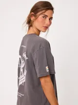 Remera de algodón color amarillo claro, con corte suelto y estampado gráfico en la espalda con diseño de muebles de playa y textos.