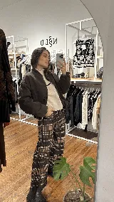 Campera tipo bomber de color marrón oscuro, con cierre frontal, cuello redondo y puños elásticos.