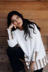 Buzo de algodón tejido a máquina con lurex, de cuerpo oversize, mangas angostas y cuello a la base. Terminaciones en crochet hechas a mano.