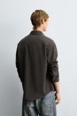 Camisa de corte relajado confeccionada en tejido fluido con mezcla de lyocell. Presenta cuello solapa, manga larga, cierre frontal con botones y un acabado con efecto lavado.