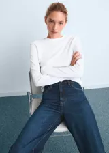 Pantalón de jean estilo wide leg con tiro alto, cierre de cremallera y botón, trabillas para cinturón y diseño de cinco bolsillos.