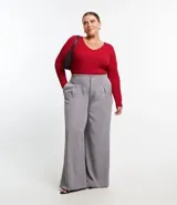 Blusa negra de punto liviano con textura acanalada, escote en pico y mangas largas.