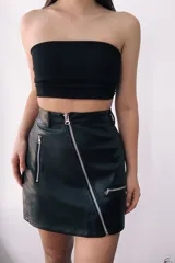 Minifalda negra de cuero sintético con cierre frontal y dos cierres laterales decorativos.