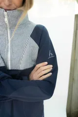 Buzo de algodón blanco con cuello alto, medio cierre frontal y panel superior capitoneado en color beige claro. Cuenta con mangas largas y bolsillos frontales.