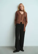 Cardigan de punto fino color marrón, con escote en V, cierre frontal de botones, manga larga y detalle de fular integrado en el cuello.