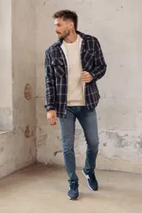 Sobrecamisa de corte holgado con diseño a cuadros en tonos azul marino y marrón, confeccionada con forro interior de corderito sintético, cuello clásico, cierre frontal de botones y bolsillos en el pecho.