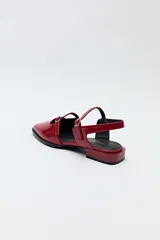 Zuecos destalonados color crema, de símil cuero, con punta cuadrada y finas tiras con hebillas ajustables. Cuentan con taco de 2,5cm de alto.