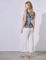 Blusa sin mangas de gasa estampada en tonos negro, blanco y celeste. Escote en V tanto en la parte delantera como en la espalda.