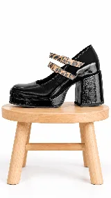 Zapatos estilo Mary Jane de cuero negro charolado, con plataforma, taco ancho y doble tira con hebilla en estampado animal print.