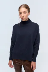 Polera tejida de punto confeccionada en lambswool, color azul marino. Cuenta con cuello alto y calce holgado.