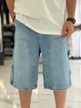 Bermuda de jean estilo carpintero, color celeste, con bolsillos laterales amplios, presilla para herramientas y diseño amplio de corte oversize.