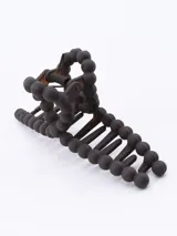 Pinza para el pelo color marrón oscuro, con forma de mandíbula y decorada con cuentas redondas.