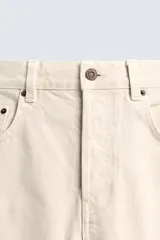 Jeans de hombre color beige claro, tiro medio, corte balloon fit con pierna relajada que se estrecha ligeramente hacia el bajo. Confeccionados en denim rígido de algodón, con cinco bolsillos y cierre frontal de cremallera y botón.