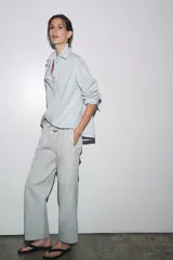 Pantalón jogger de la colección Zara Woman, color gris claro, confeccionado en hilatura con algodón y lyocell. Presenta tiro medio, cintura elástica ajustable con cordones, bolsillos laterales ocultos en costura y pierna ancha.