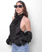 Anteojos de sol negros, montura gruesa y rectangular, con lentes oscuros. Presentan una firma manuscrita en la patilla derecha.